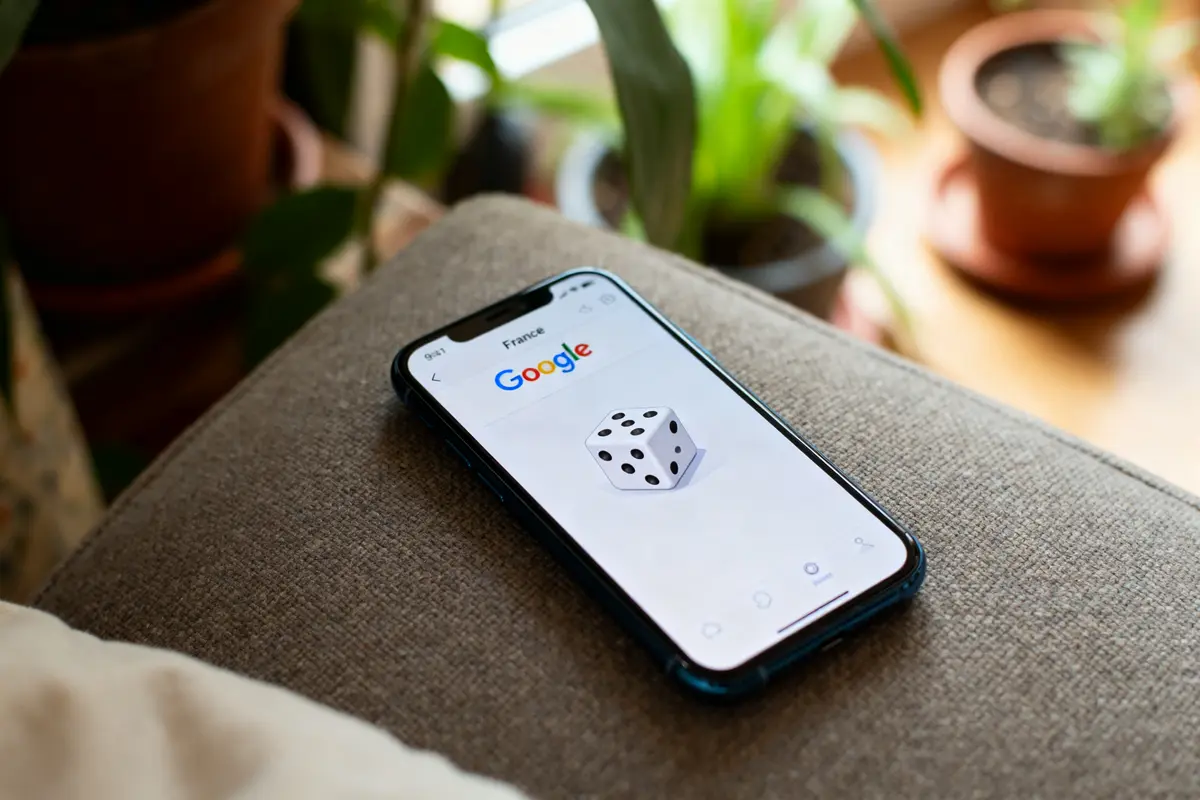 Smartphone affichant le dé Google pour lancer le dé virtuel sur un canapé