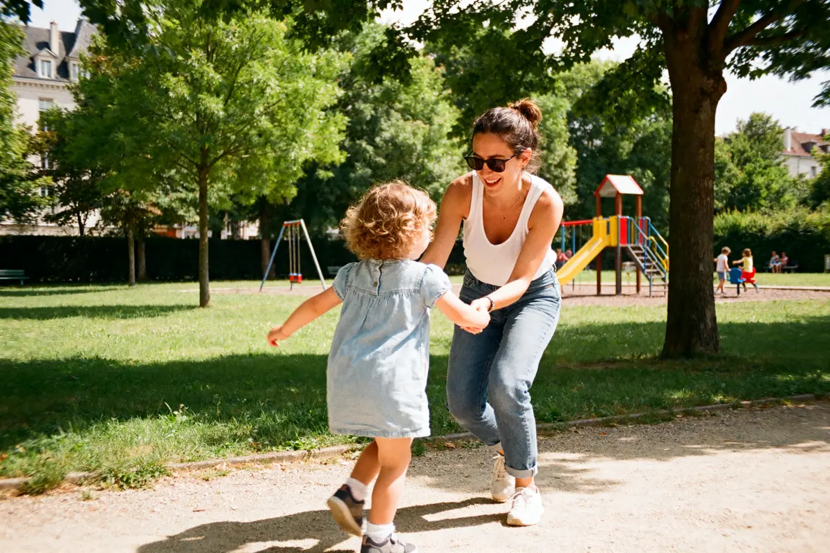 Mère et enfant jouent au parc avec joie petitpasparental blog.