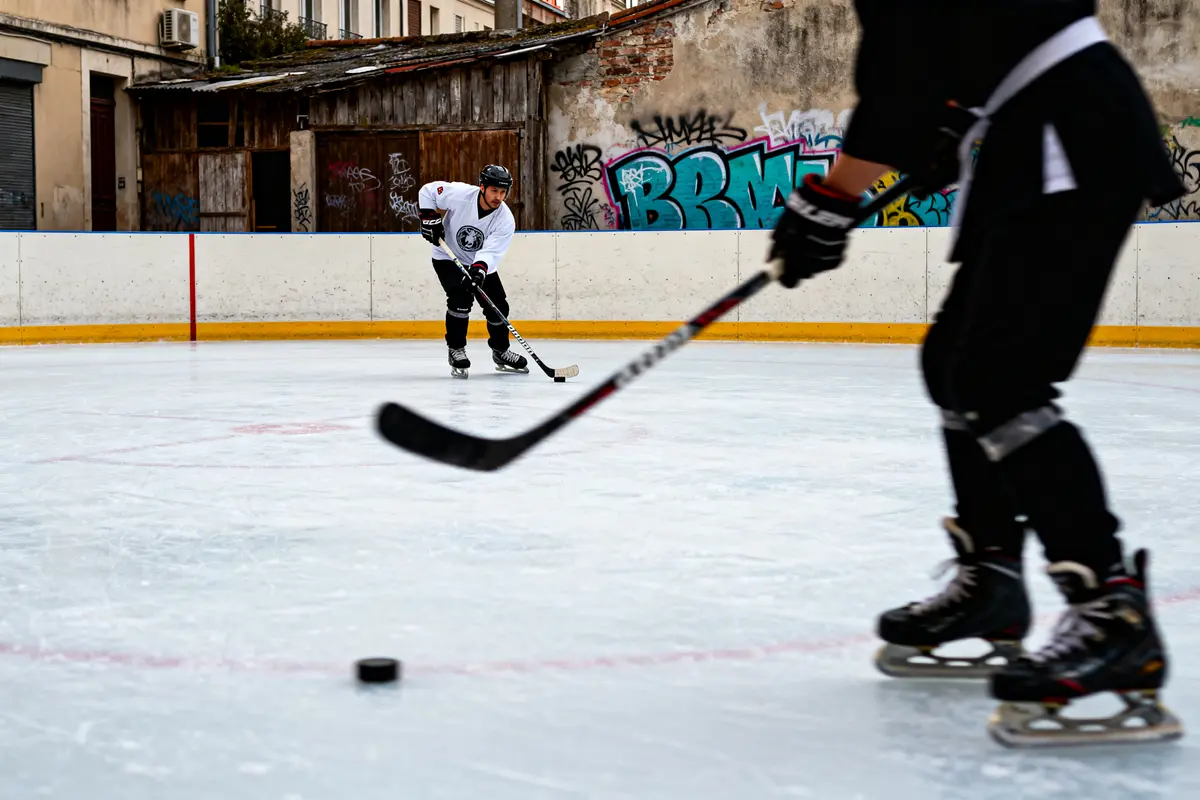 Deux joueurs de hockey en action sur patinoire extérieure, sport en I dynamique.